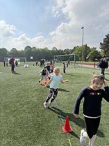 Foto:Kinder springen an einer Hindernisstation. 