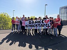 Foto: Die Schüler stehen vor dem Stadion mit einem Danke an die Kindertafel!